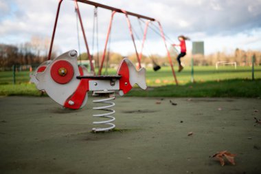 Bir bahar ve salıncak arka planda ahşap balıklı Çocuk Bahçesi