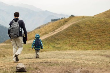 Baba ve oğul dağ görünümünde geri. Aile aktiviteleri