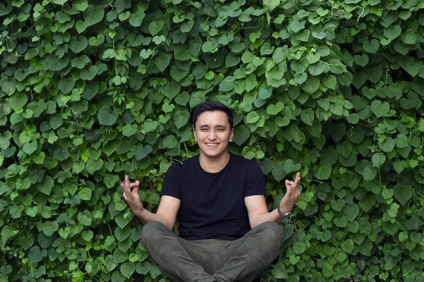 smiling asian young man posing yoga