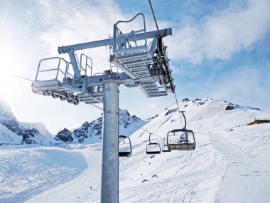 Güneşli bir gün sandalye asansörde. Çevrelerindeki bir inanılmaz dağ manzarası.