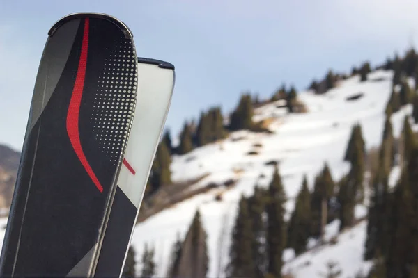 A pair of skis on mountain background. Close up. Copy space.