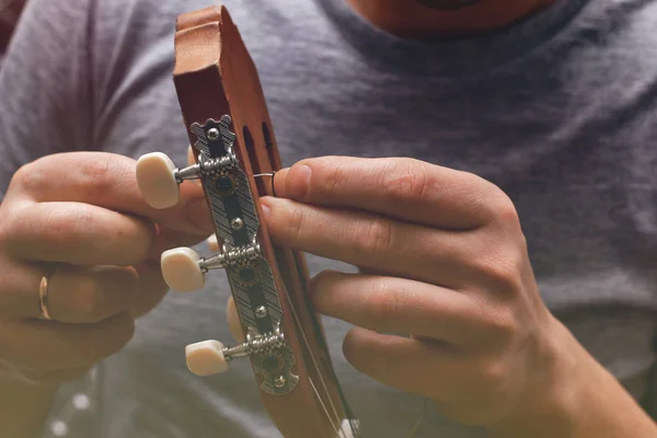 Close up view on string changing process on acoustic guitar's neck — Stock Photo, Image