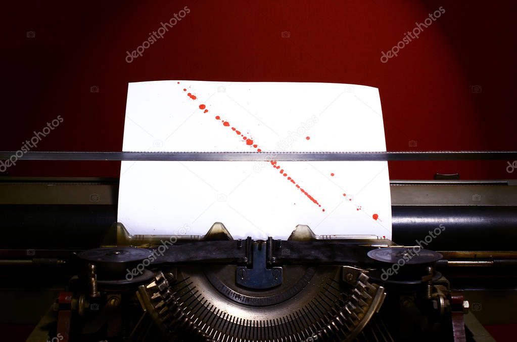 Typewriter with blood splashes on paper background