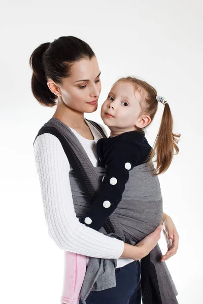 Una bambina nella croce anteriore porta l'involucro in un marsupio tessuto — Foto Stock