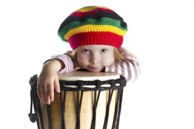 Toddler girl portrait in rastafarian hat with drum