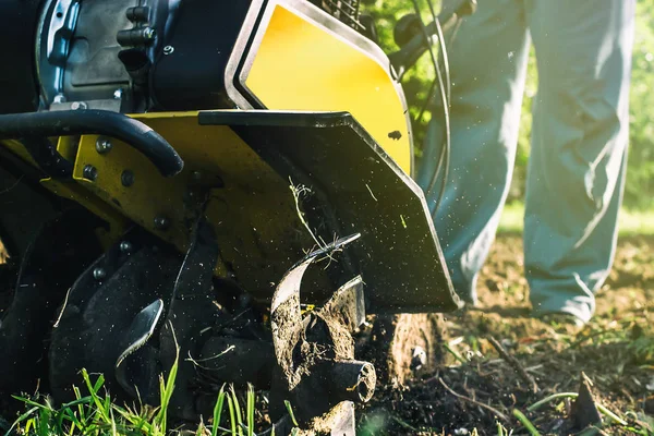 Um homem arar um solo por motor cultivador vista inferior — Fotografia de Stock