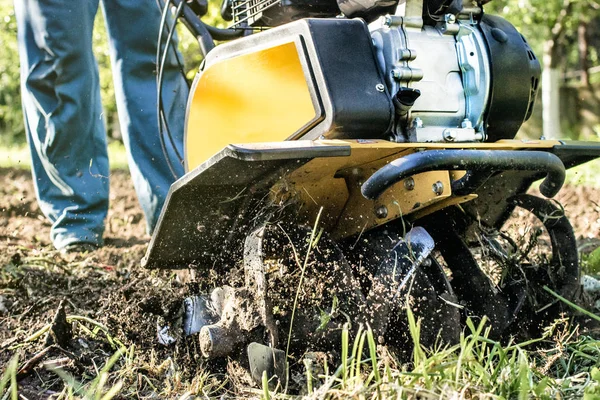 Um homem arar um solo jardim por motor cultivador vista inferior — Fotografia de Stock