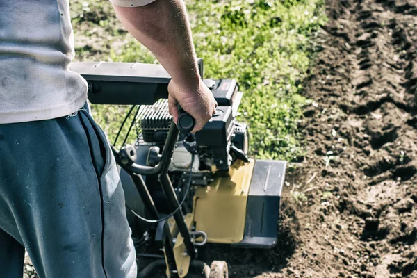 Un cultivador de motor arando un crudo en tierra de germen — Foto de Stock