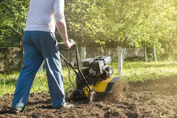 Un homme labourant un sol par motoculteur perspective vue — Photo