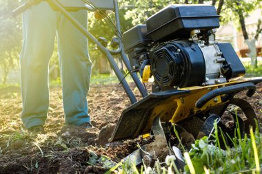 Motor kültivatör çiftliği çalışmaları sırasında çim ve sürülmüş toprak külçeleri