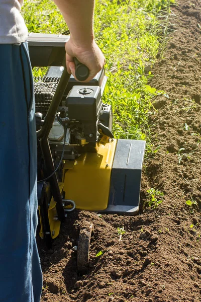 Trabalho de arado de jardim ao ar livre com cultivador de motor vertical — Fotografia de Stock