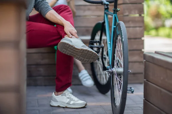 Hombre joven en pantalones rojos al lado de la bicicleta de pista —  Fotos de Stock