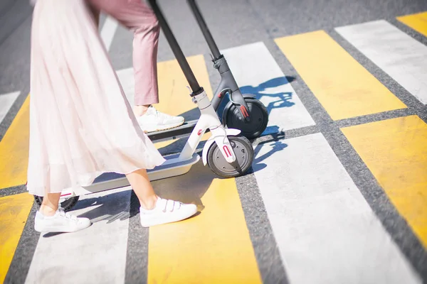 Patas de mujer y piernas de hombre caminando con scooters en cruce de caminos —  Fotos de Stock