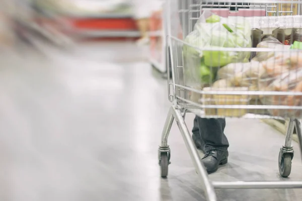 Ember sétál a kocsi között sorok hűtőszekrények. vásárlási koncepció — Stock Fotó