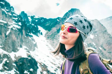 Sırt çantası dağlarda yürüyüş ile seyahat kız, özgürlük kavramı. Asya'da yürüyüş yapanlar. Sırt çantası ile güzel genç kadın gezgin tırmanmadan önce dağın tepesine bakar