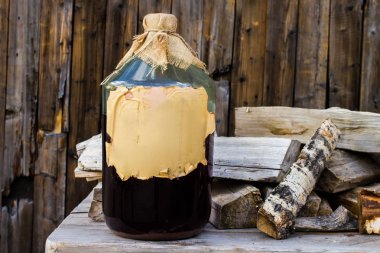 Ahşap bir masa üzerinde büyük bir cam şişe de Craft alkol huş tentürü, Rus halk tarifi.