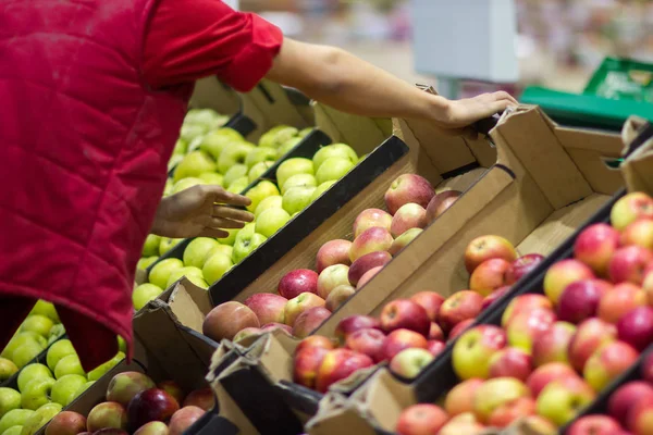 Verkäufer legt frisches Obst aus der Kiste im Supermarkt aus — Stockfoto