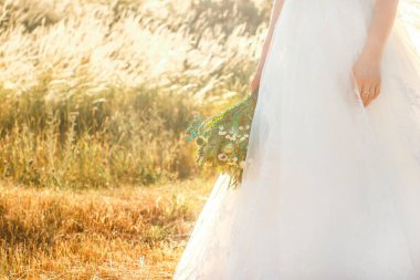 Tourquoise renk detayları ile rustik düğün buketi tutan parmaklarında tırnak sanat ve yüzük ile gelin kolu na yakın görünümü.