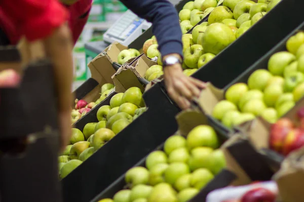 Verkäufer legt frisches Obst aus der Kiste im Supermarkt aus — Stockfoto