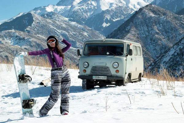 Almaty, Kazajstán - 10 de enero de 2019: UAZ 452 y snowboard burton girl en la montaña Tian-Shan en freeride — Foto de Stock