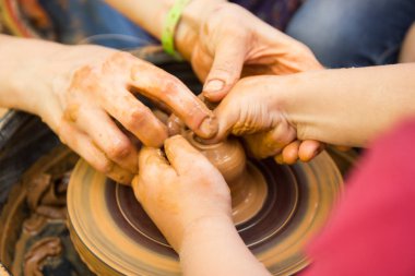Çocuklarla çömlekçi tekerleğinde seramik üretim sürecine yakından bak. Çocuk konsepti ile Kil el sanatları.
