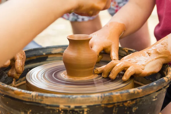 Vue rapprochée sur le processus de production de céramique sur la roue du potier avec les enfants. Artisanat en argile avec concept enfants . — Photo