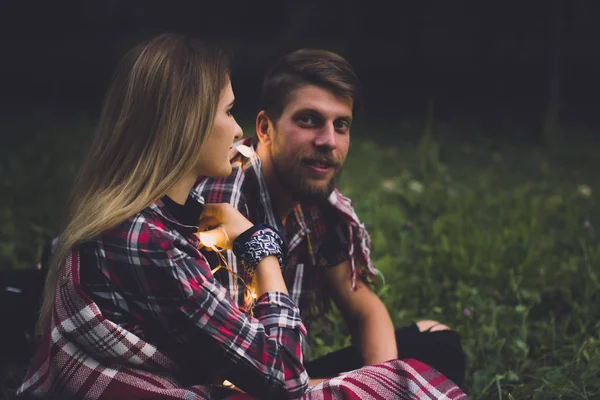 Un joven par de amantes perdieron el tren. Tocando la canción con la guitarra en los rieles en el bosque de otoño esperando el próximo tren. — Foto de Stock