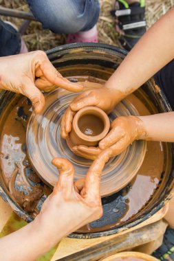Çocuklarla çömlekçi tekerleğinde seramik üretim sürecine yakından bak. Çocuk konsepti ile Kil el sanatları.