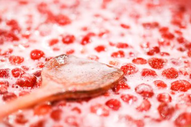 Çilek reçeli pişirme işlemi. Reçel yüzeyinde tahta kaşık liying. Organik geleneksel reçel imalatı.