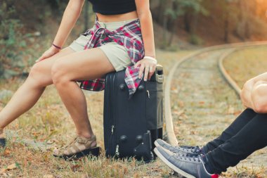 Trende bavulları olan genç bir çift. Aşıklar treni rayların üzerinde bekliyor. Çaresiz gezginler sonbaharda gün batımında trenin arkasında kaldılar..