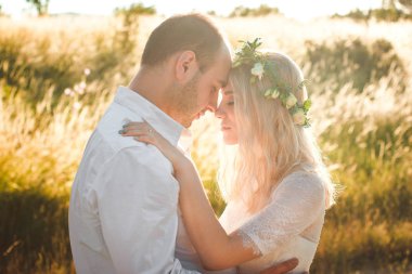 Güneşli yaz gününde el ele tutuşan gelin ve damadın geri görünümü. Açık düğün ve ilişki koyun romantik kavram