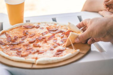 Sosis ve peynirile yakın çekim bütün pizza. Plaj yemekleri.