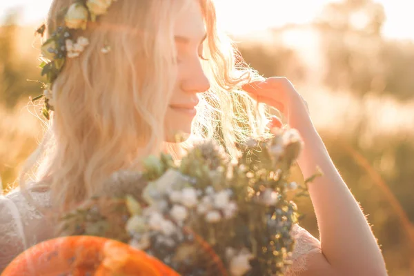 Güzel genç kadın portre alanında yaz aylarında bir çiçek çelenk ile boho tarzında beyaz bir elbise. Seçici yumuşak odaklama. — Stok fotoğraf