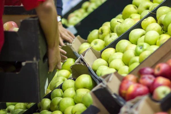 Verkäufer legt frisches Obst aus der Kiste im Supermarkt aus — Stockfoto