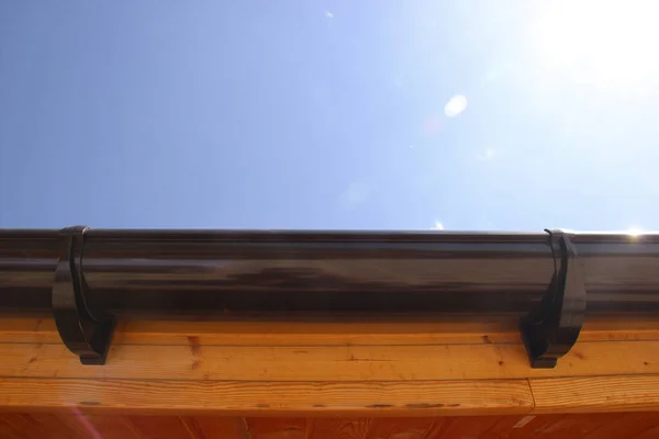家の屋根の上の排水システム 茶色のプラスチック排水 — ストック写真