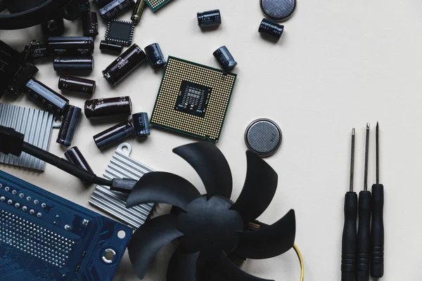 Computer and laptop hardware - CPU, fan cooler, battery, capacitors, radiator, chip on the white background with copy space, flat lay. PC parts top view. Repair, assembly, engineering concept.