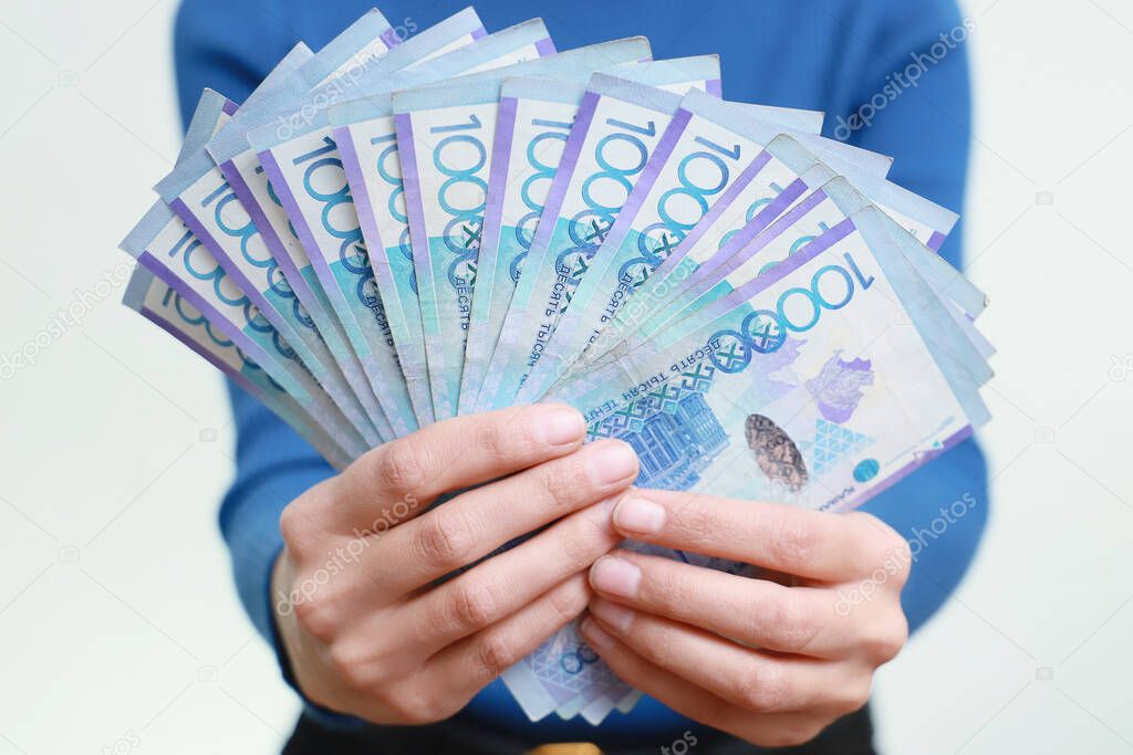 Kazakhstan money tenge in hands against the background of a person. Face value is ten thousand.