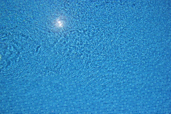 Вид сверху на прозрачную воду на голубом фоне бассейна. Волновой эффект — стоковое фото