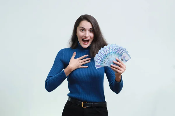 Uma Mulher Bonita Diverte Ganhando Dinheiro Tenge Fundo Branco Uniforme — Fotografia de Stock