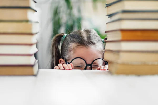 Büyük Gözlüklü Kuyruklu Küçük Bir Kız Bir Yığın Kitap Okumaktan — Stok fotoğraf
