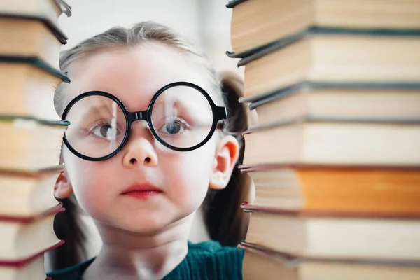 Potter Tarzı Gözlüklü Kız Iki Kitap Yığınının Arasına Bakıyor — Stok fotoğraf