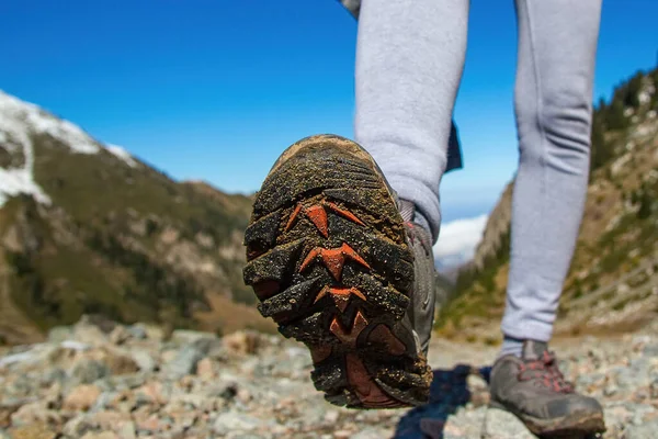 The sole of the boot is close-up. Slender women 's legs amid the slope.