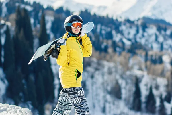 Mladá Žena Žluté Bundě Snowboardem Ramenou Dívá Sjezdovku — Stock fotografie