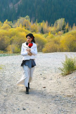 Güzel, genç bir anne ve bebeği dışarıda asılıymış. Anne çocuğunu taşıyor ve sonbahar dağında seyahat ediyor. Bebek giyme konsepti
