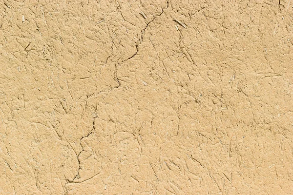 Adobe - clay and straw material weathered wall of rural old country house close-up as clay background