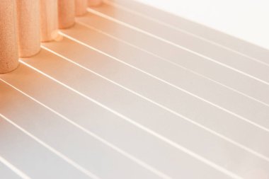 Düz çizgilerin gölgeleri, güneşli renklerde beyaz yüzeyde geometri ışığı oluşturur.