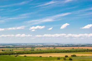 Bulutlu mavi gökyüzüne karşı parlak manzaranın havadan görünüşü. Skyline. Kırsal bölgelerdeki tarım alanları.
