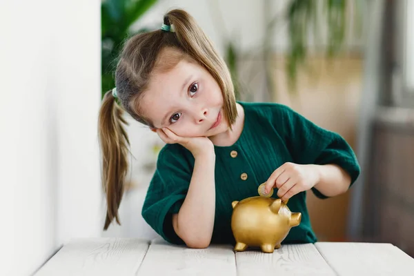 Sladká Školačka Dává Mince Zlaté Prasátko Banky Stolu Uvnitř Primární — Stock fotografie