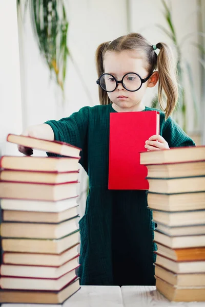 Mała Dziewczynka Blond Włosami Okrągłych Okularach Między Książkami Domu Zostań — Zdjęcie stockowe