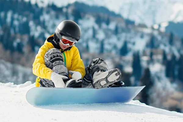 Joven Snowboarder Sienta Nieve Sujeta Las Sujeciones Una Tabla Snowboard — Foto de Stock